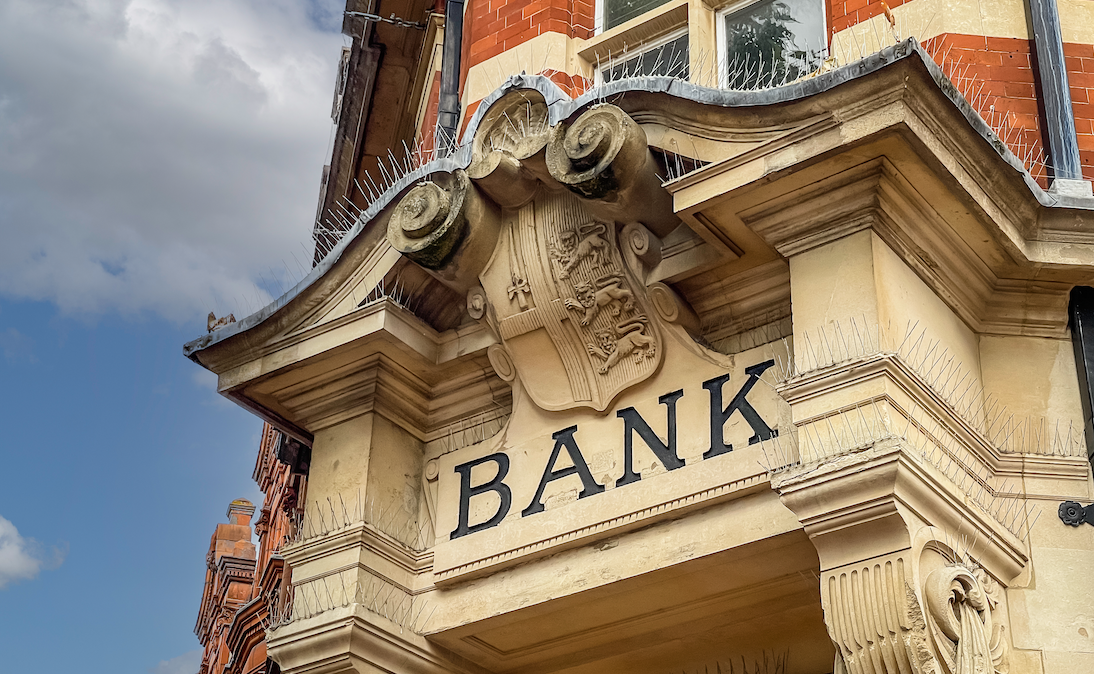 The stone facade of a British bank, with ornate scrollwork and the word 